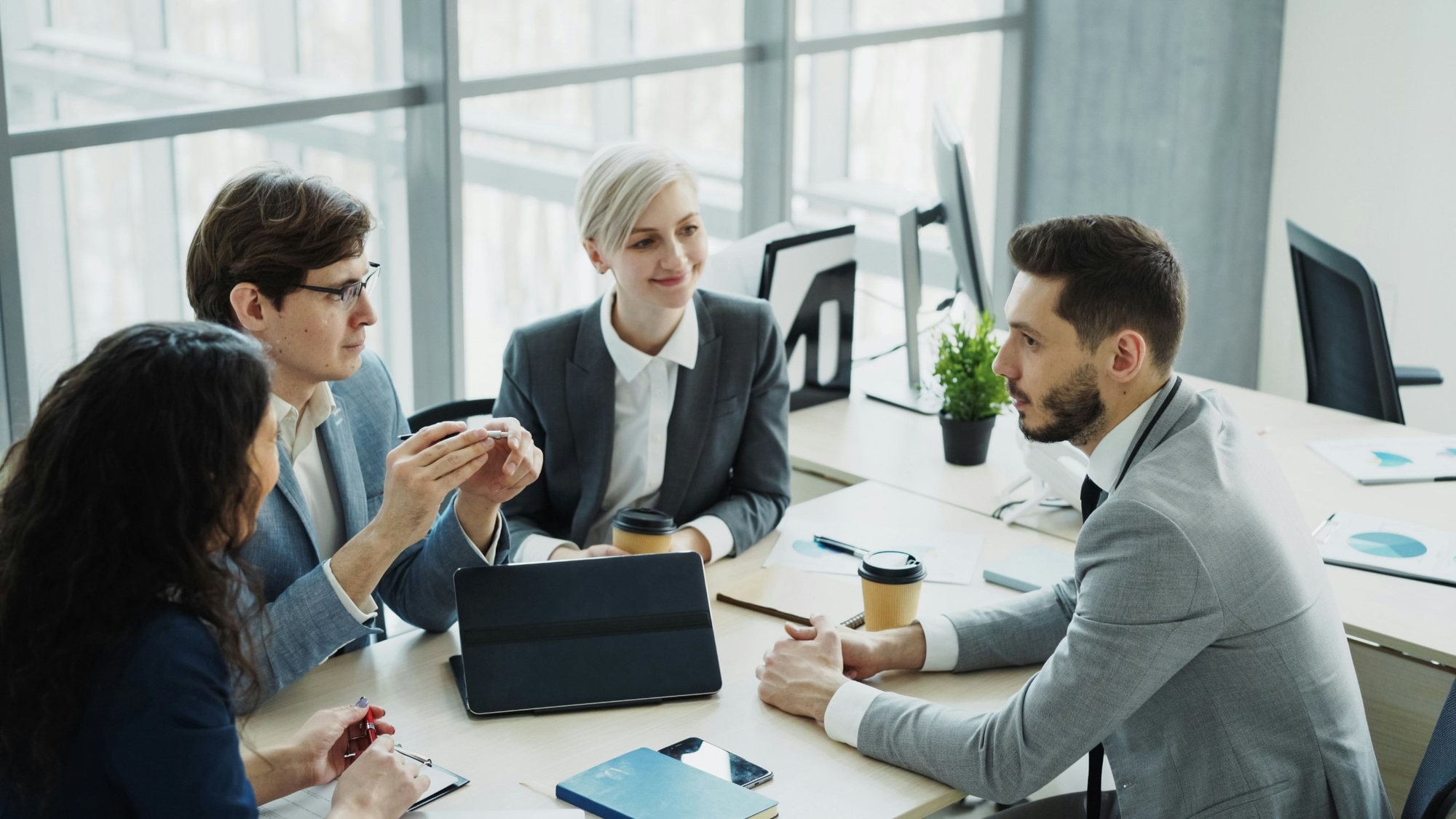 Un líder conduce una conversación de equipo en una oficina moderna